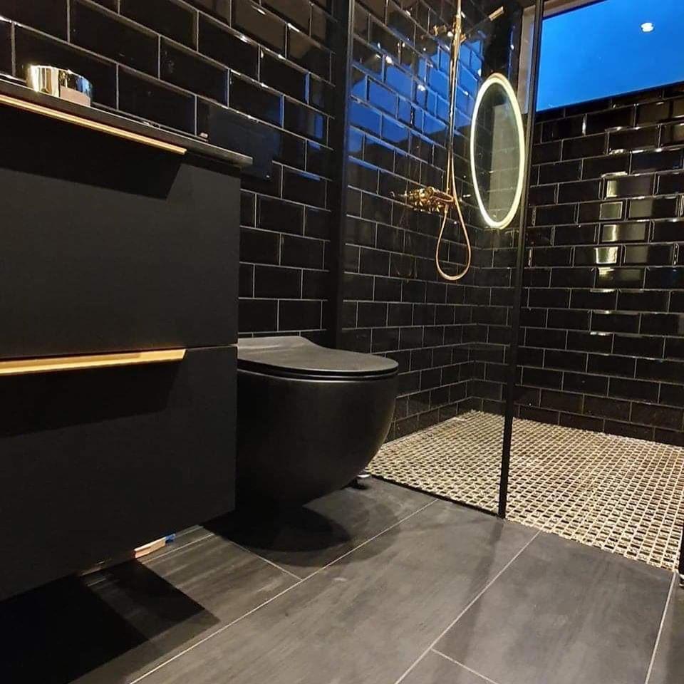 A bathroom in black tiles with a black wall-hung toilet