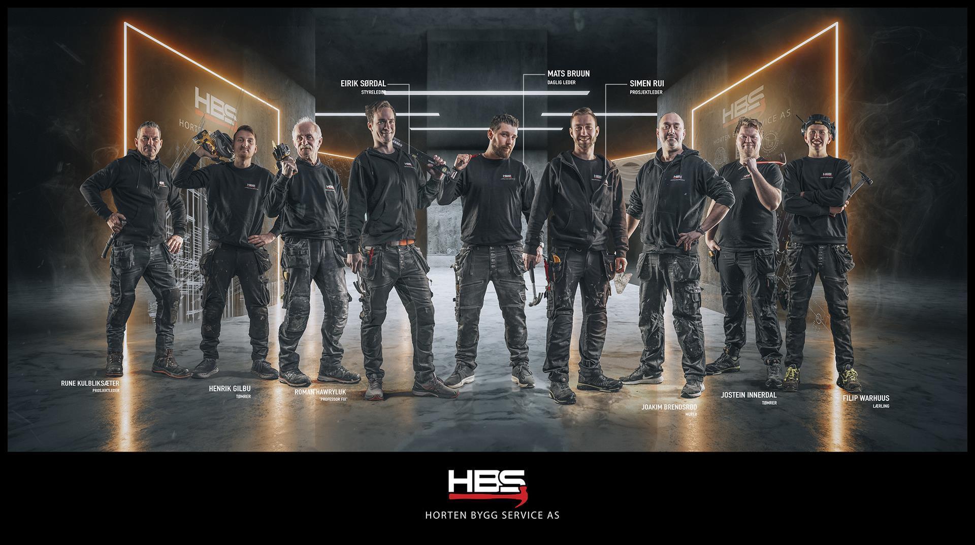The Horten Bygg Service team in black work clothes, standing in a row in a dark studio